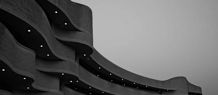 Rows of identical seats repeating into the distance, in black and white.